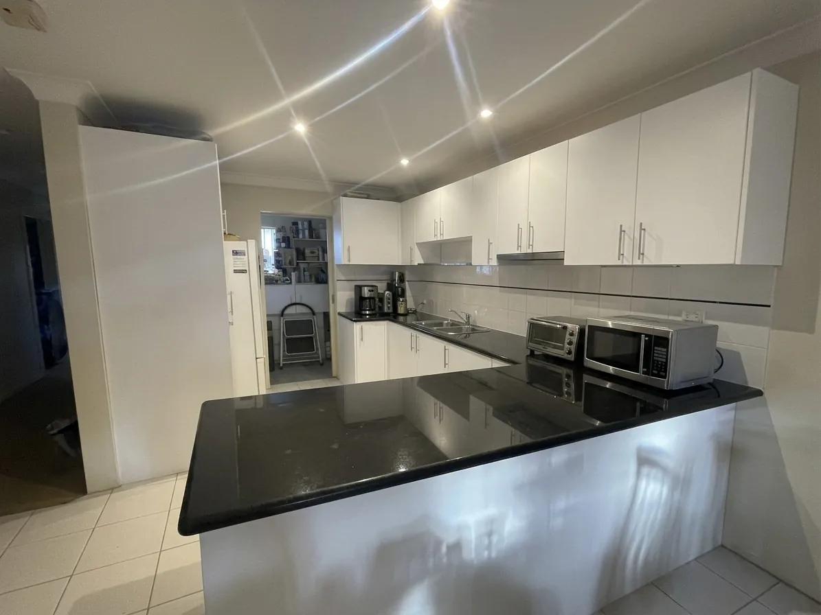 Refinished white 2pac apartment kitchen with black benchtop in Alexandria