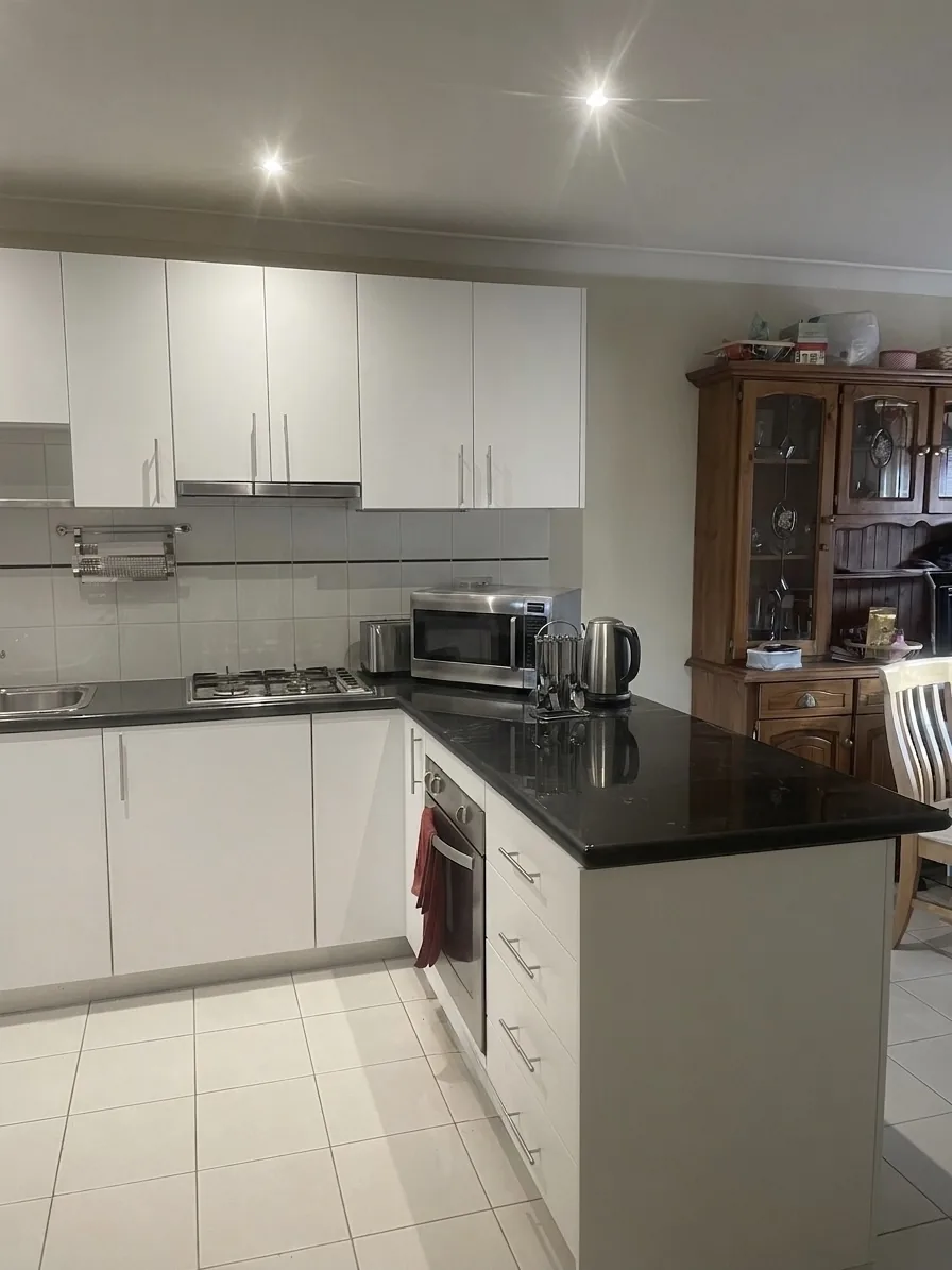 Refinished apartment kitchen showing the oven run and overhead cabinets in Alexandria