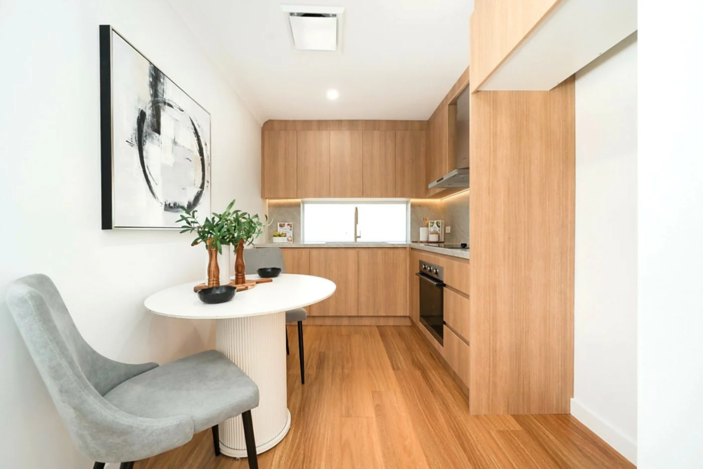 Epping secondary kitchen zone with full timber cabinetry, sink and small dining setting