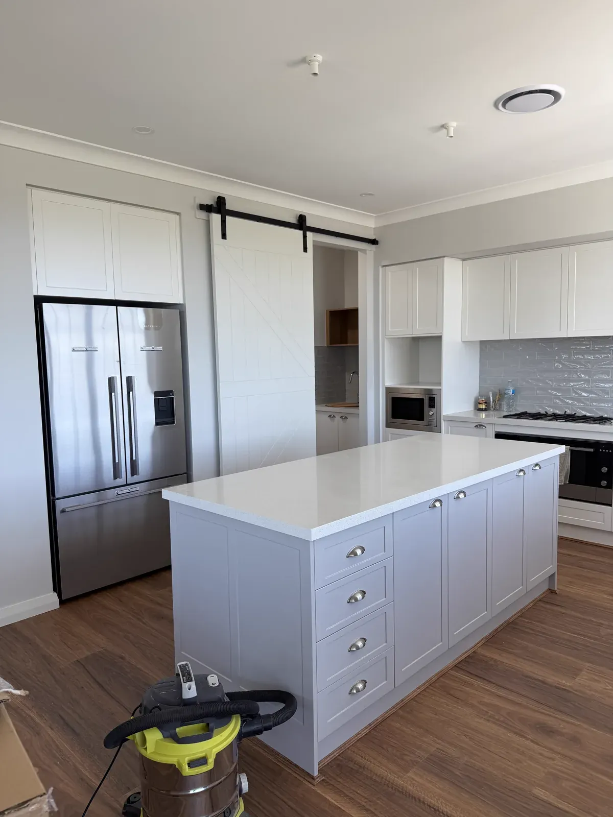 Kiama upstairs kitchen — Dulux Vivid White shaker matching the downstairs kitchen