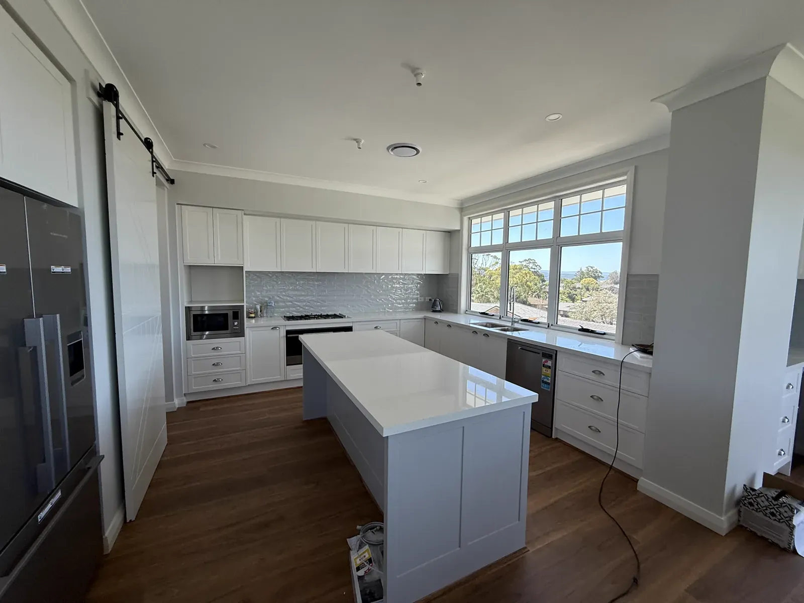 Kiama upstairs kitchen — Dulux Vivid White shaker matching the downstairs kitchen