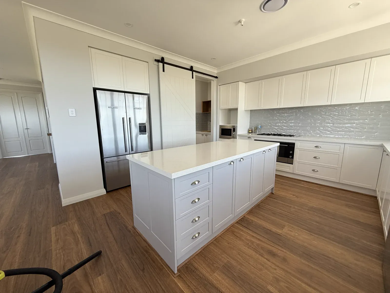 Kiama upstairs kitchen — wide angle with V-groove barn door visible