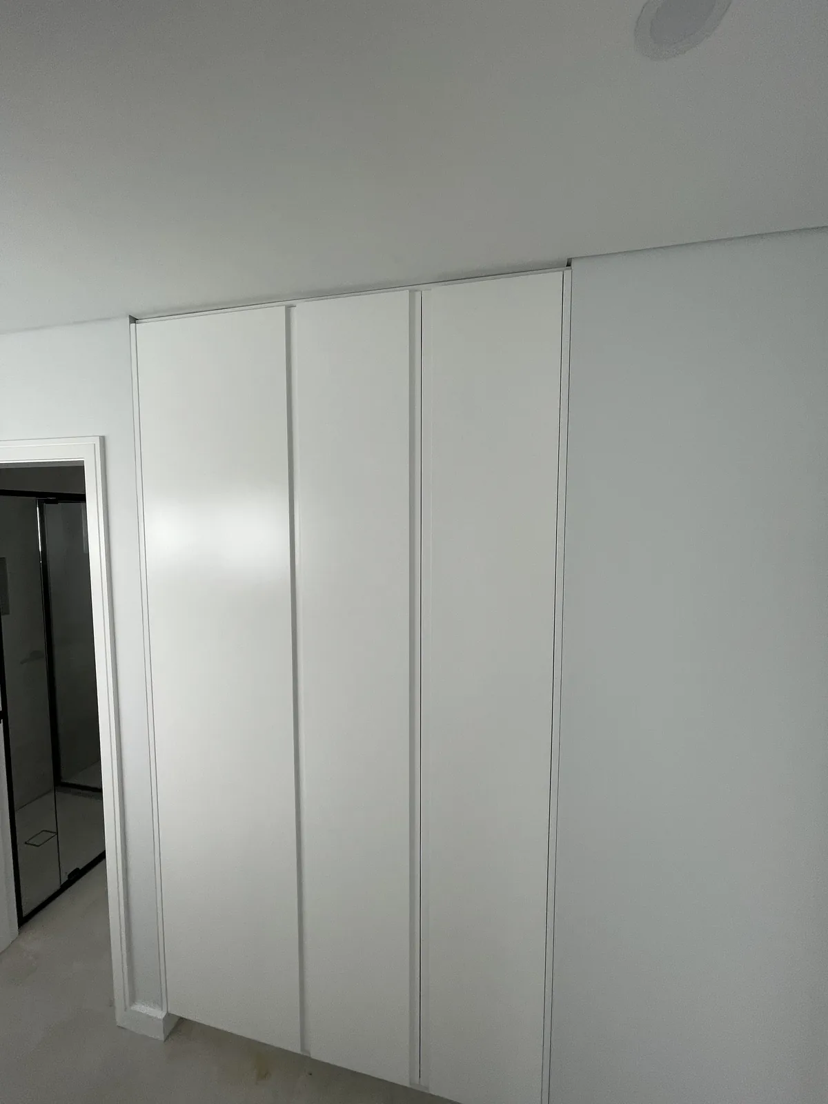 Vivid White full-height joinery run with grooved fingerpull doors in a Leichhardt home