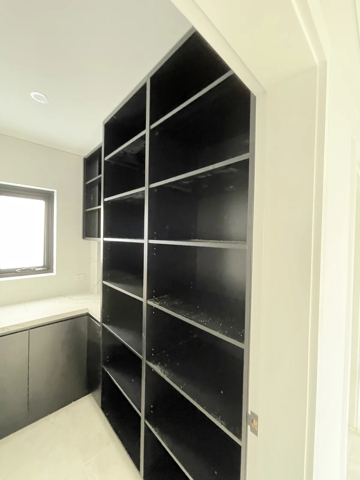 Full-height black open shelving in a walk-in pantry in Leichhardt
