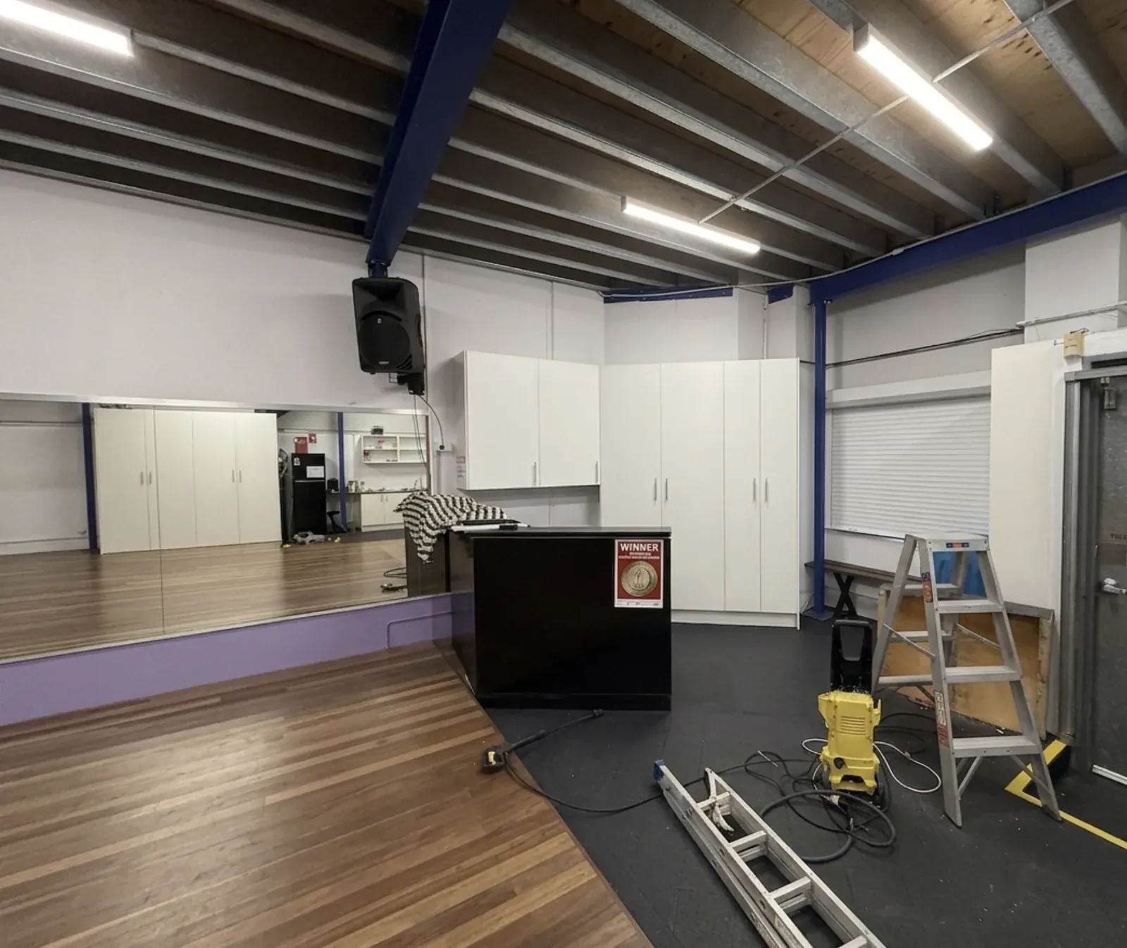 Mascot dance studio floor with completed white storage cabinetry along the wall