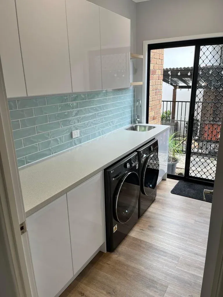 Castle Hill completed laundry with teal splashback and overhead cabinetry