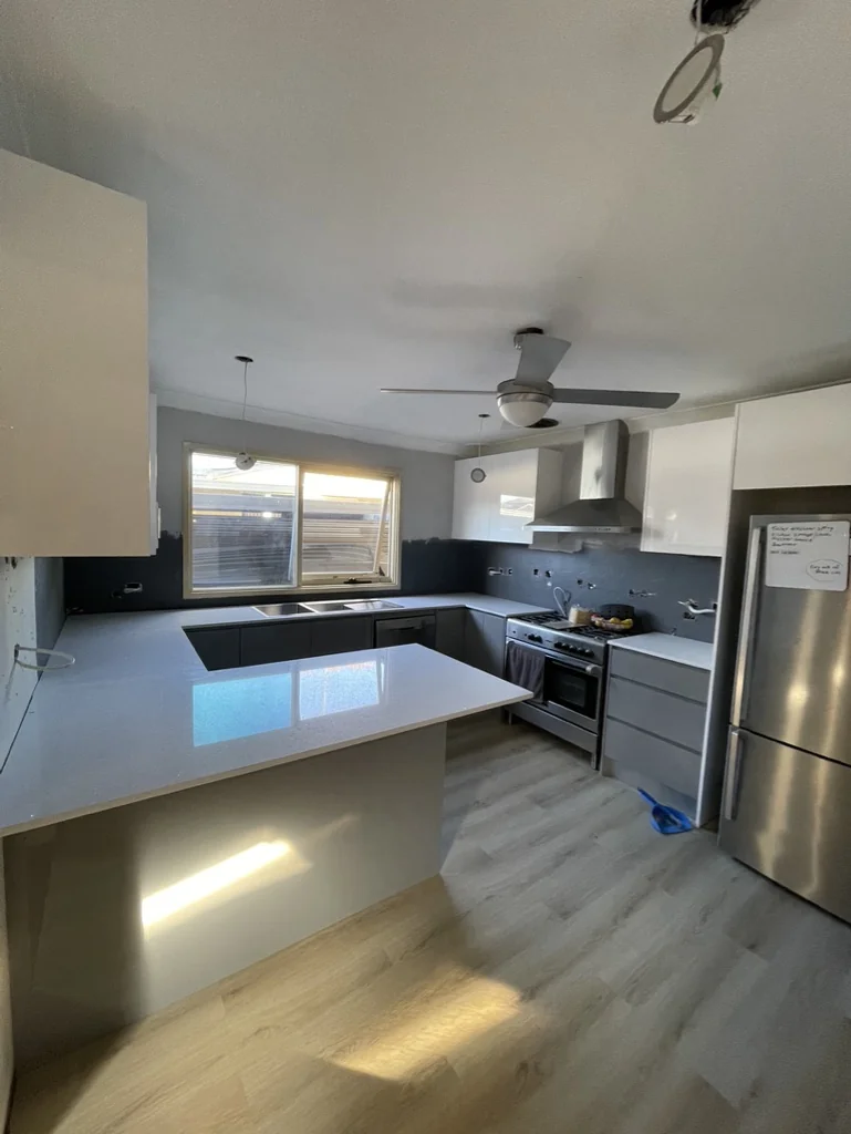 Lurnea kitchen island foreground with new joinery and appliances