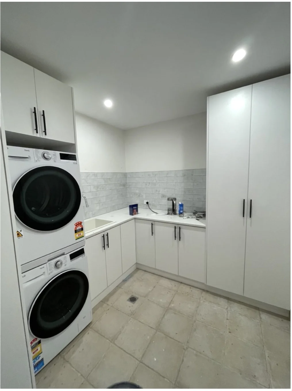 Neutral Bay L-shape laundry — stacked washer dryer, Calacatta benchtop, full-height pantry
