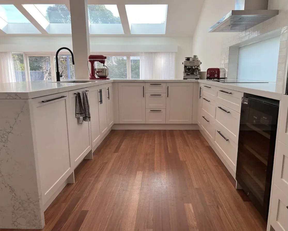 Neutral Bay kitchen — U-shape interior showing undermount sink on island, concealed dishwasher and wine fridge, skylights above