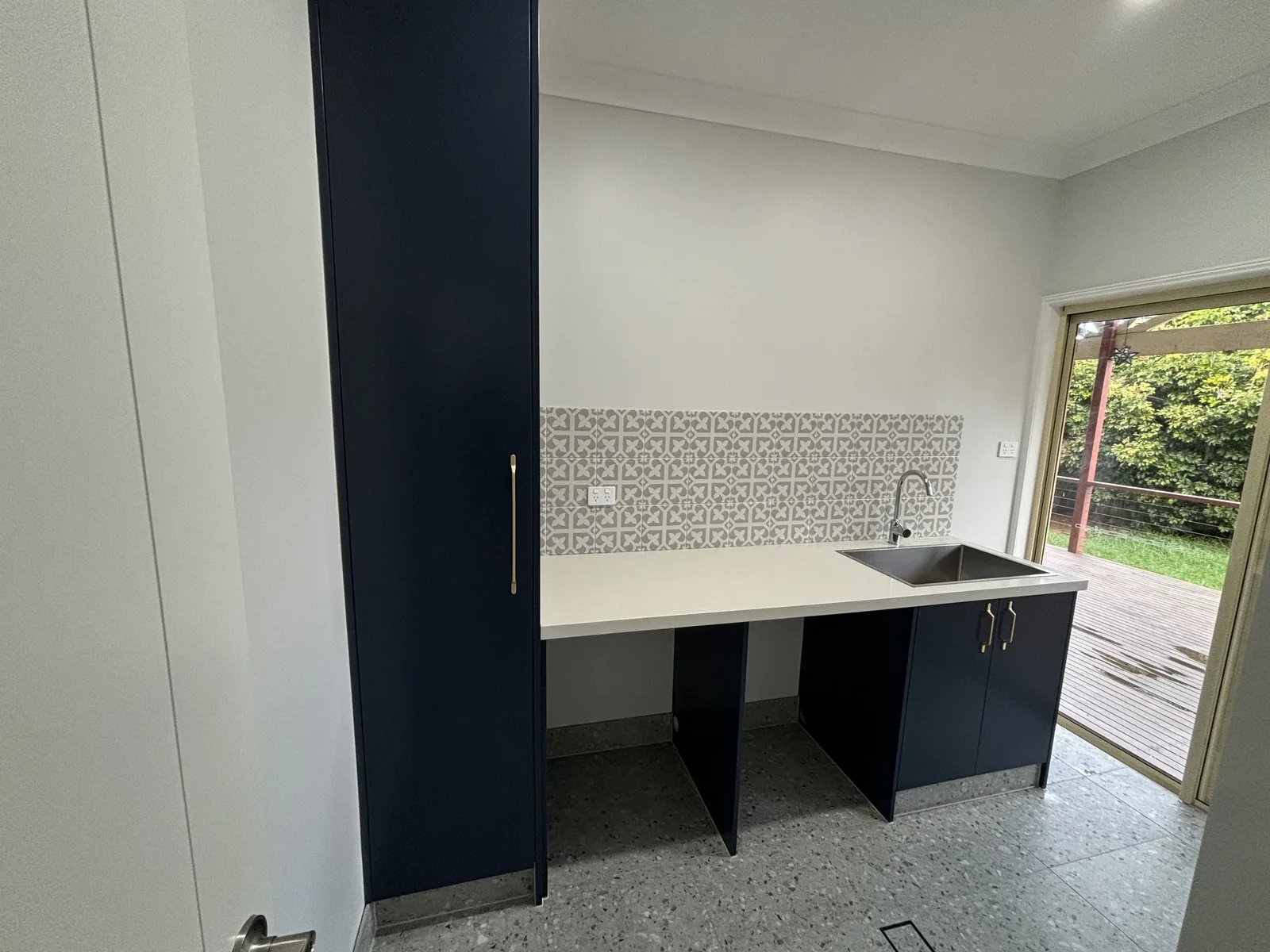 Completed Stanhope Gardens laundry with navy 2pac joinery and appliance bays