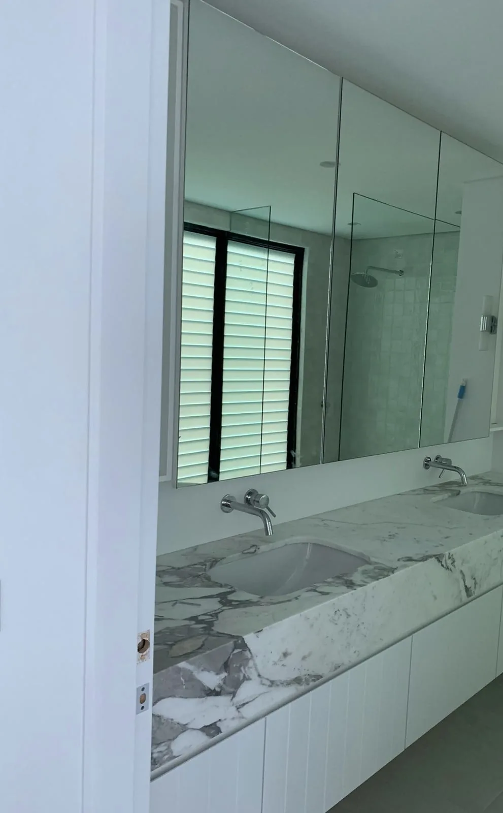 Ensuite vanity reflected in the mirror in a Waverley home