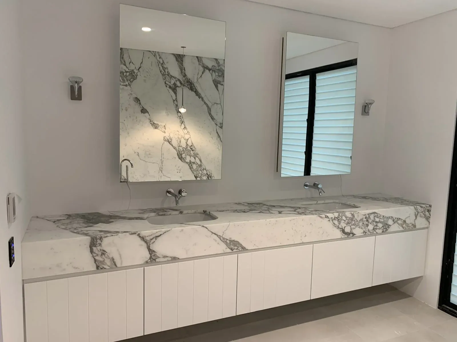 Double vanity with twin mirrors and a stone top in a Waverley main bathroom
