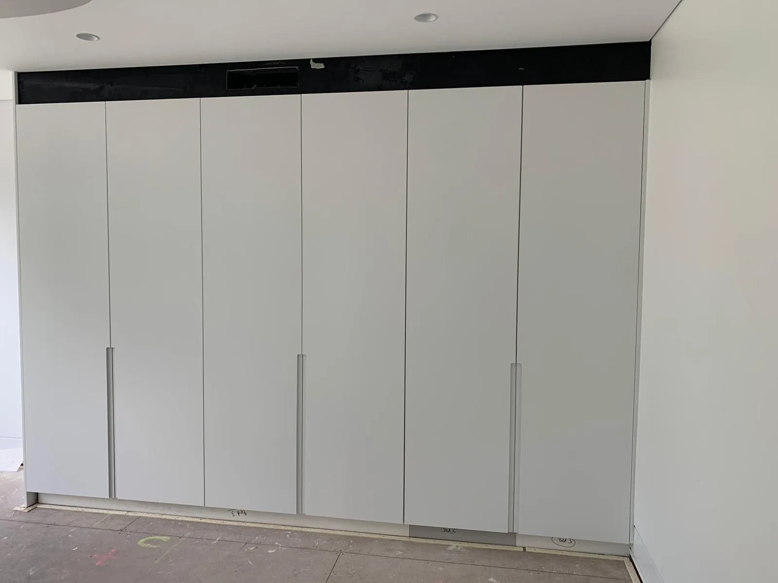 Wardrobe run finished in white polyurethane seen from the side in Waverley