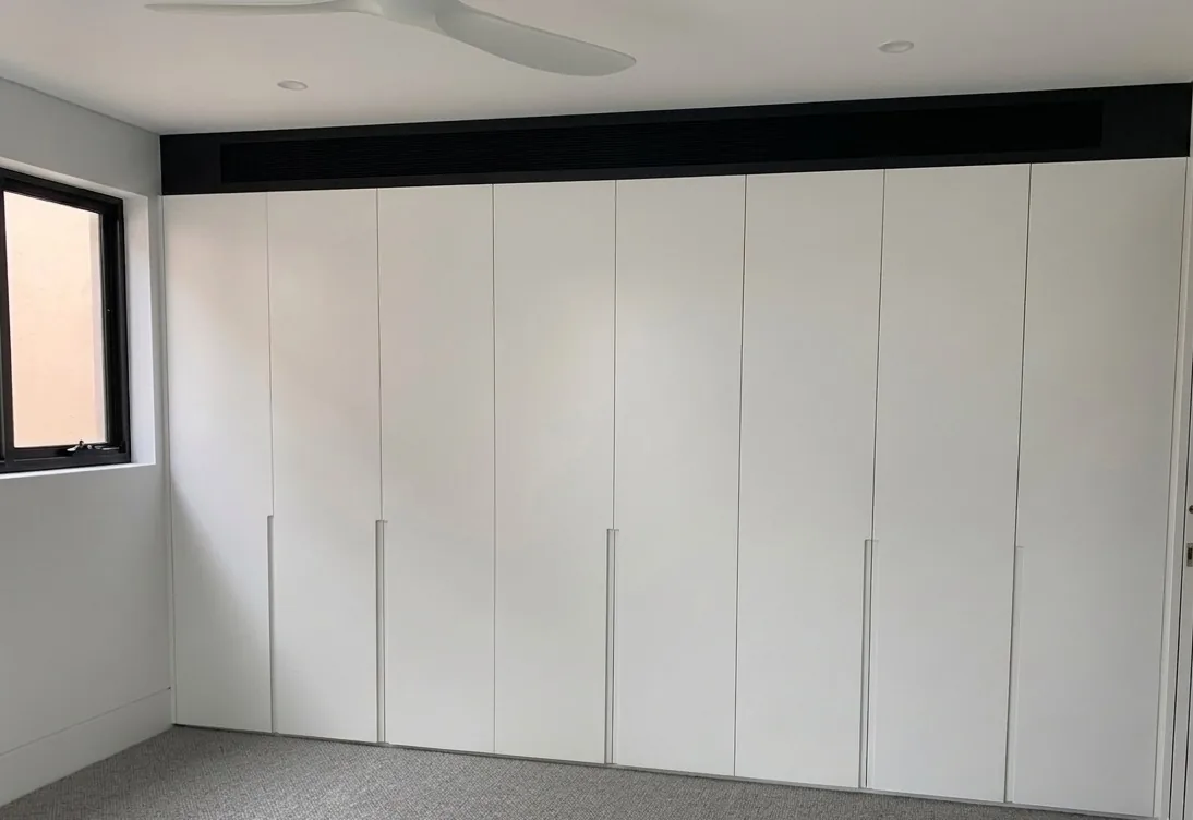 White polyurethane wardrobe with integrated J-pull in a Waverley bedroom