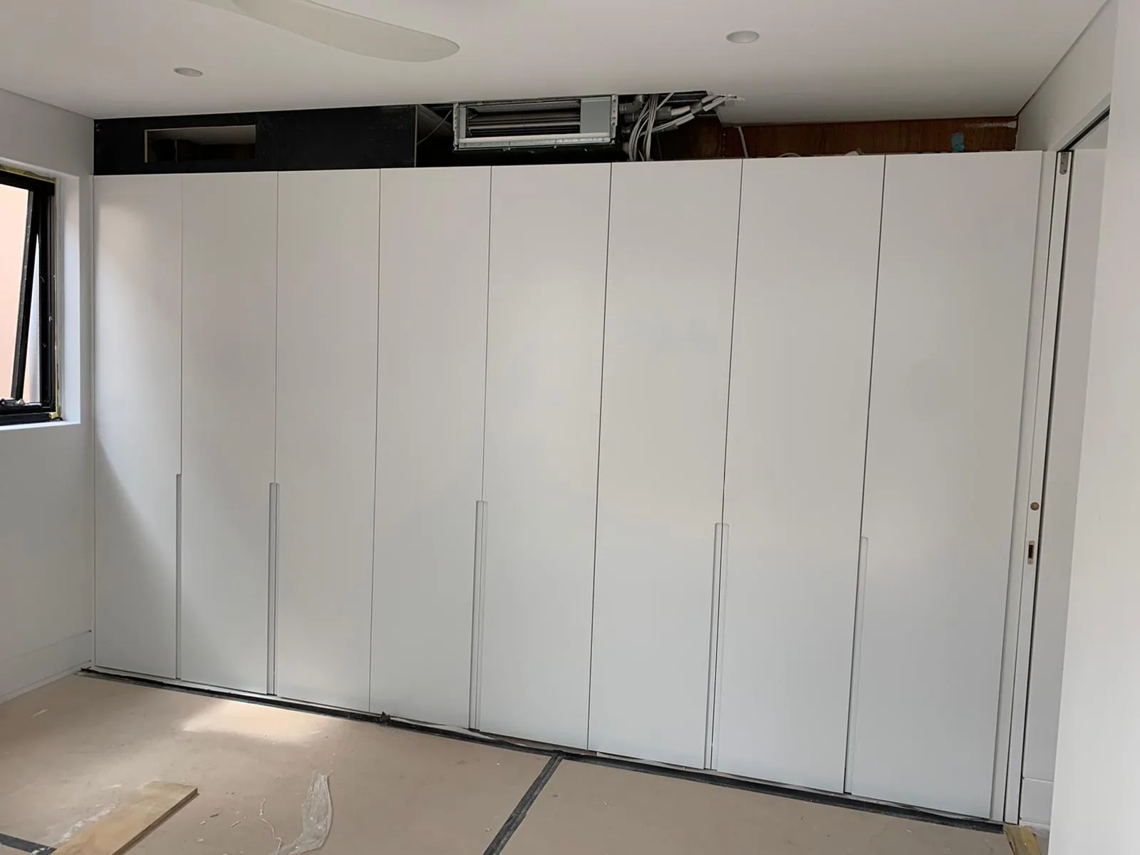 Full wall of white polyurethane wardrobe doors in a Waverley bedroom