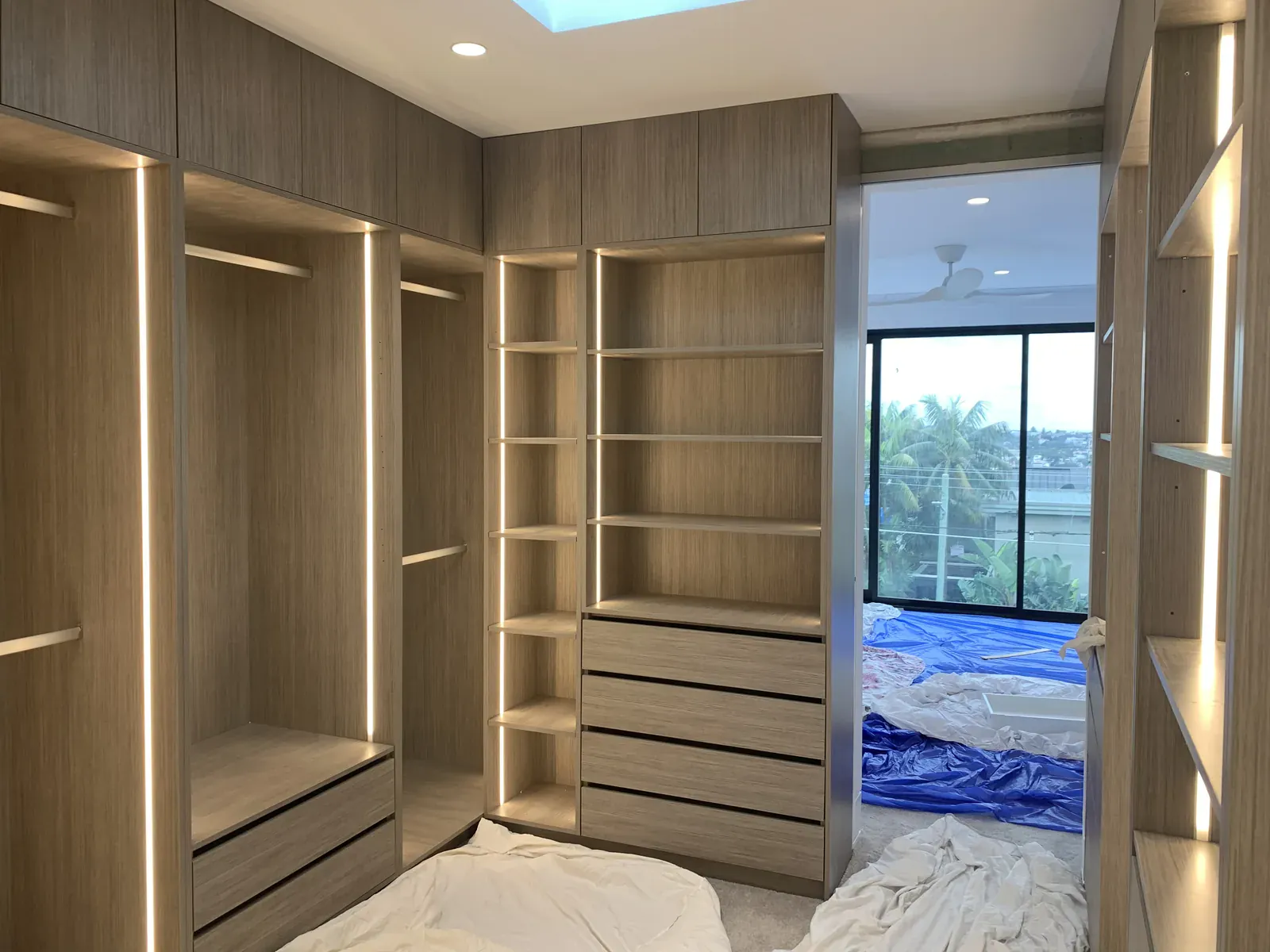 Walk-in robe in Polytec Manor Oak Woodmatt with vertical grooved LED lighting in Waverley