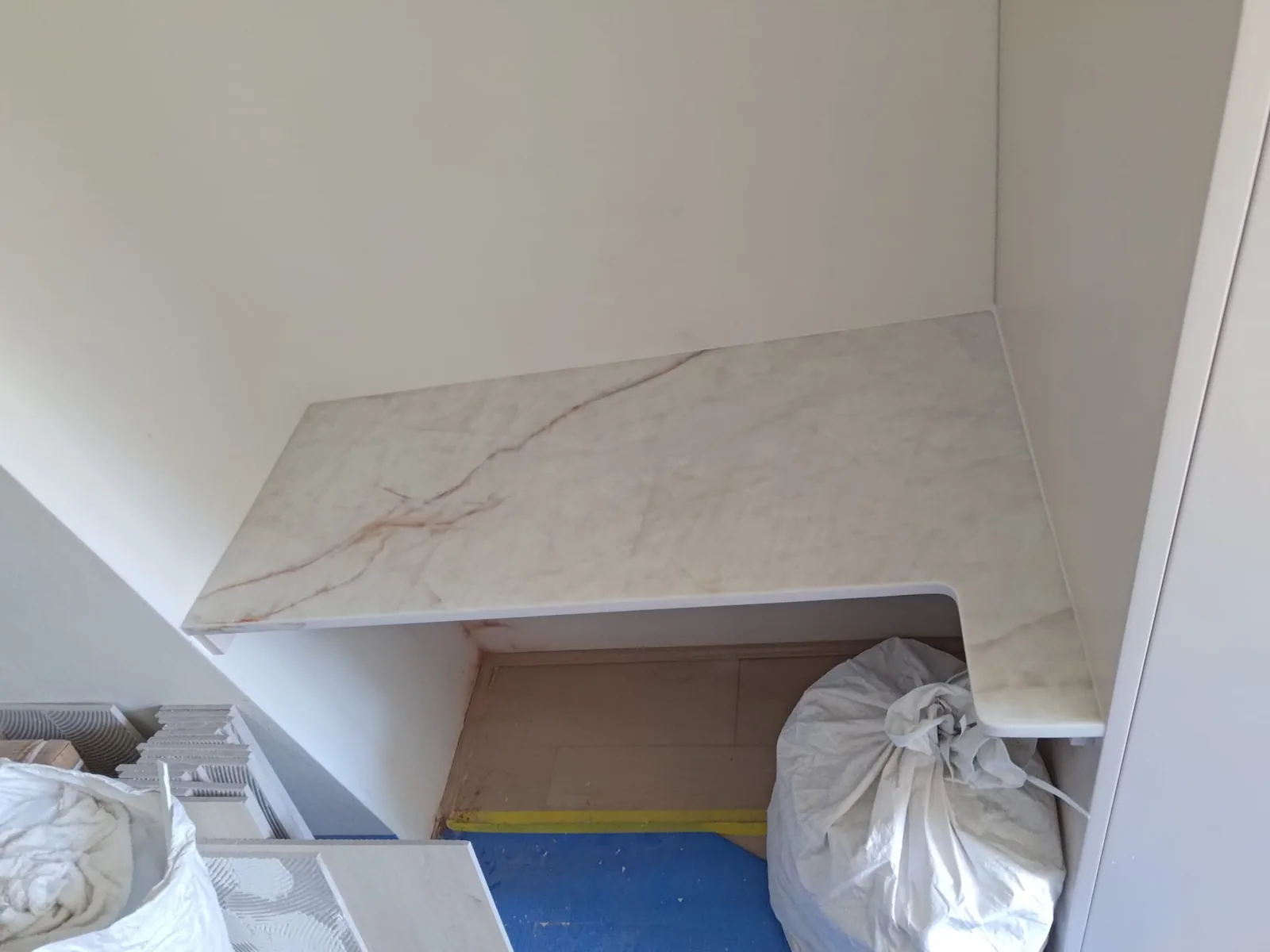 Stone benchtop study desk beside hallway pantries in a Willoughby apartment