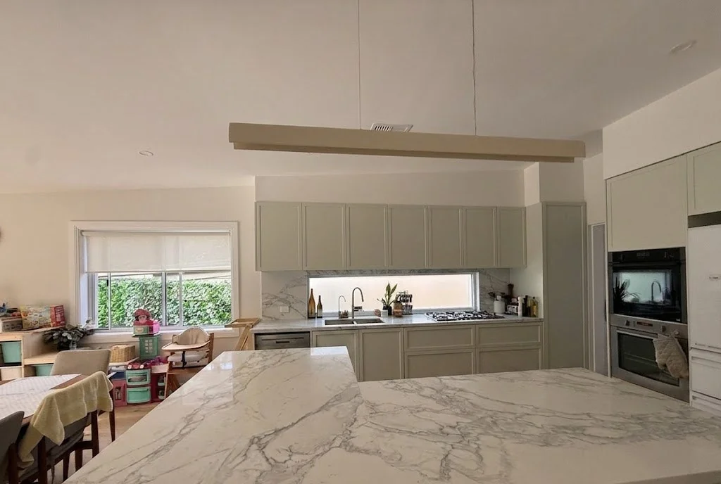 Willoughby kitchen island angle — marble benchtop with oven tower in background
