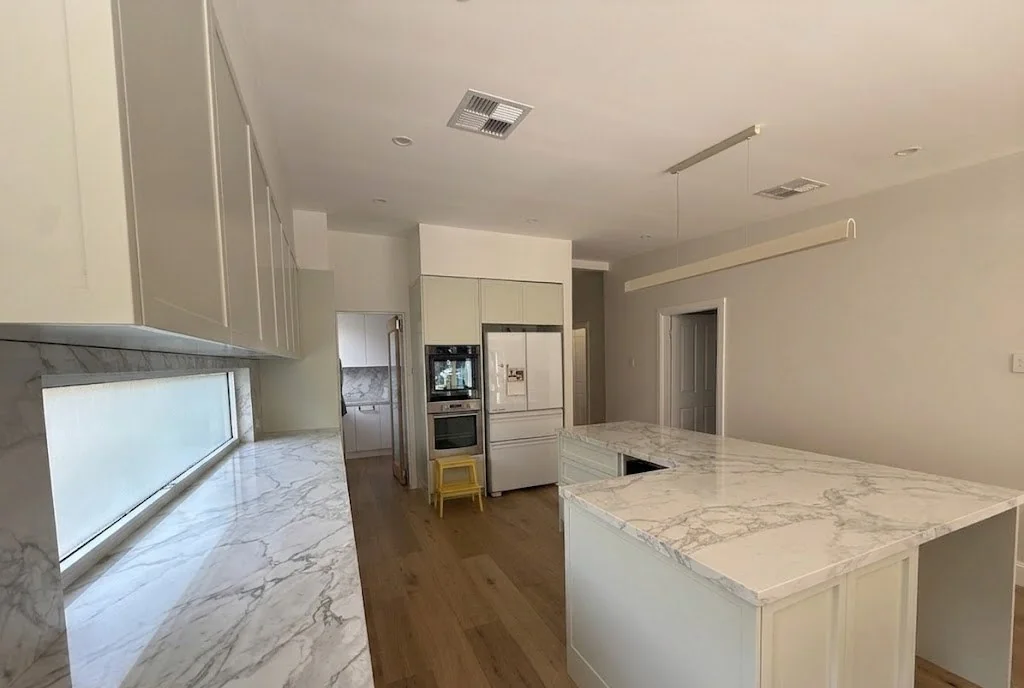 Willoughby kitchen — view from island toward fridge, oven tower and window