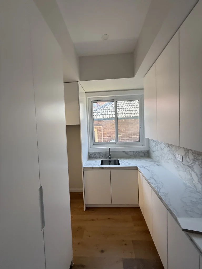 Willoughby laundry — full room view showing cabinetry, window and floor
