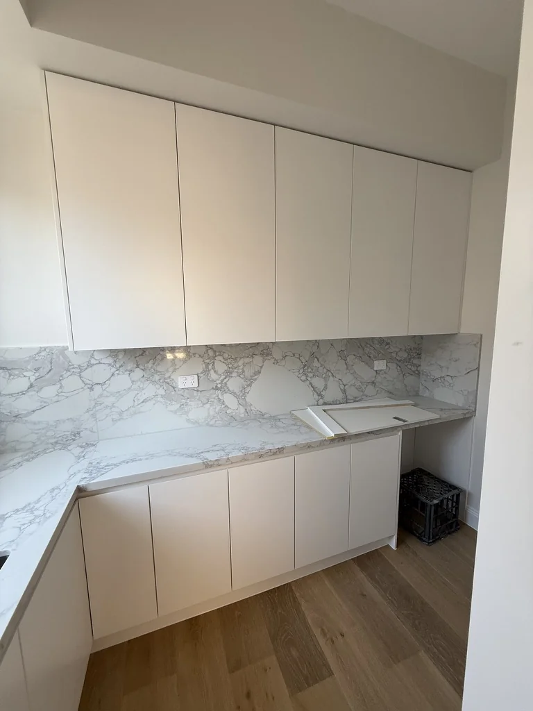 Willoughby laundry — overhead cabinetry and marble splashback wide view